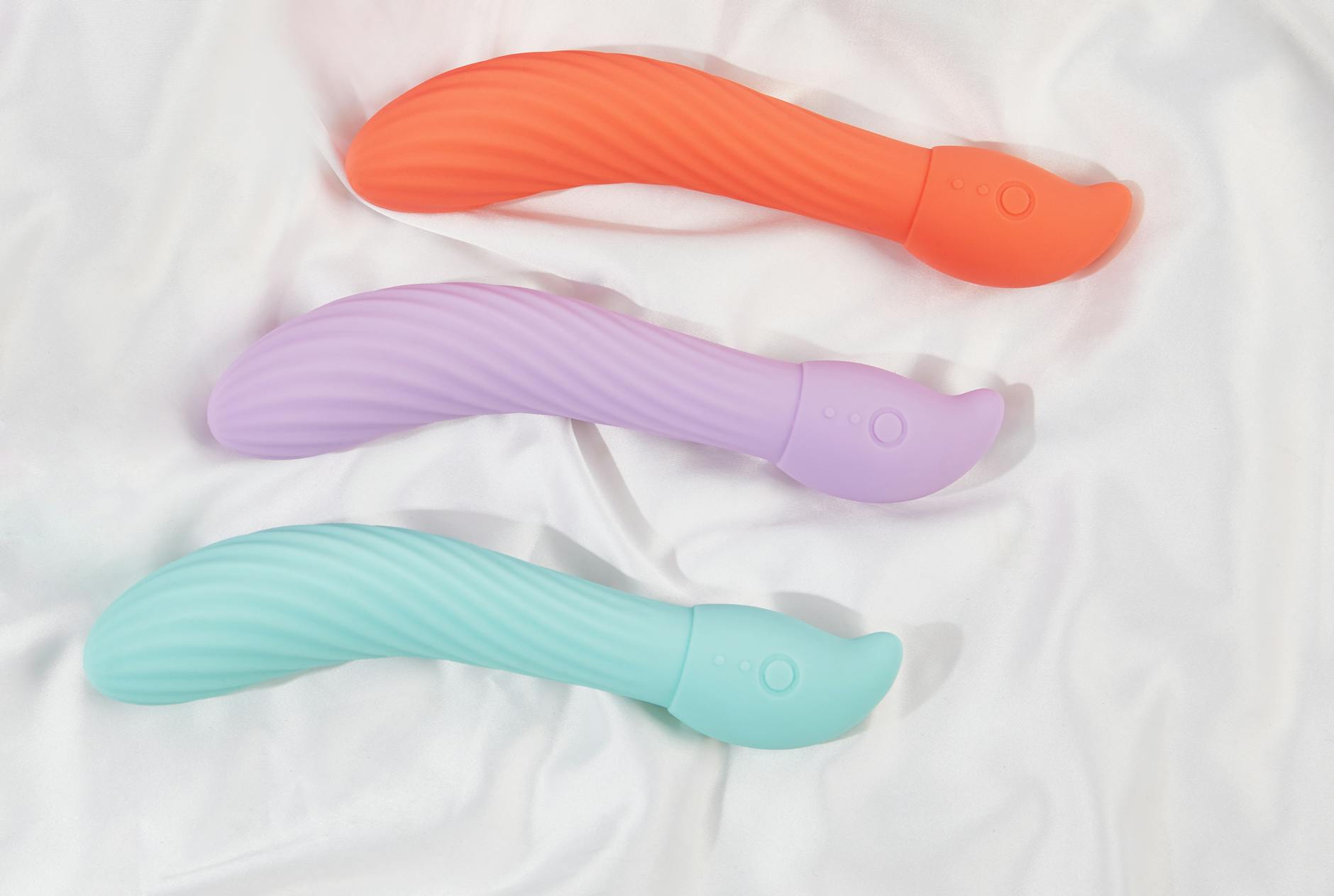 Three colorful lemon vibrators arranged on white fabric, highlighting smooth texture and ready for use.