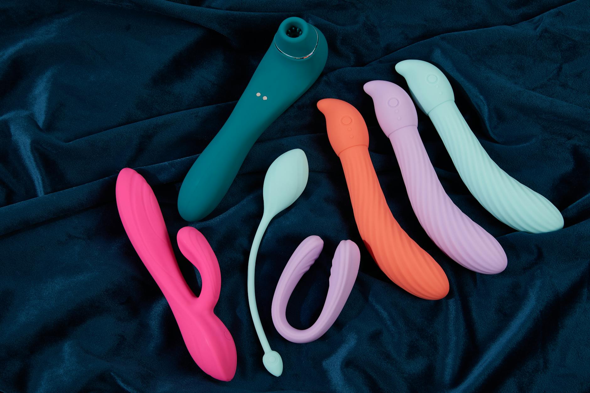 Yellow silicone vibrator with fresh fruit on bright background, representing playful intimacy