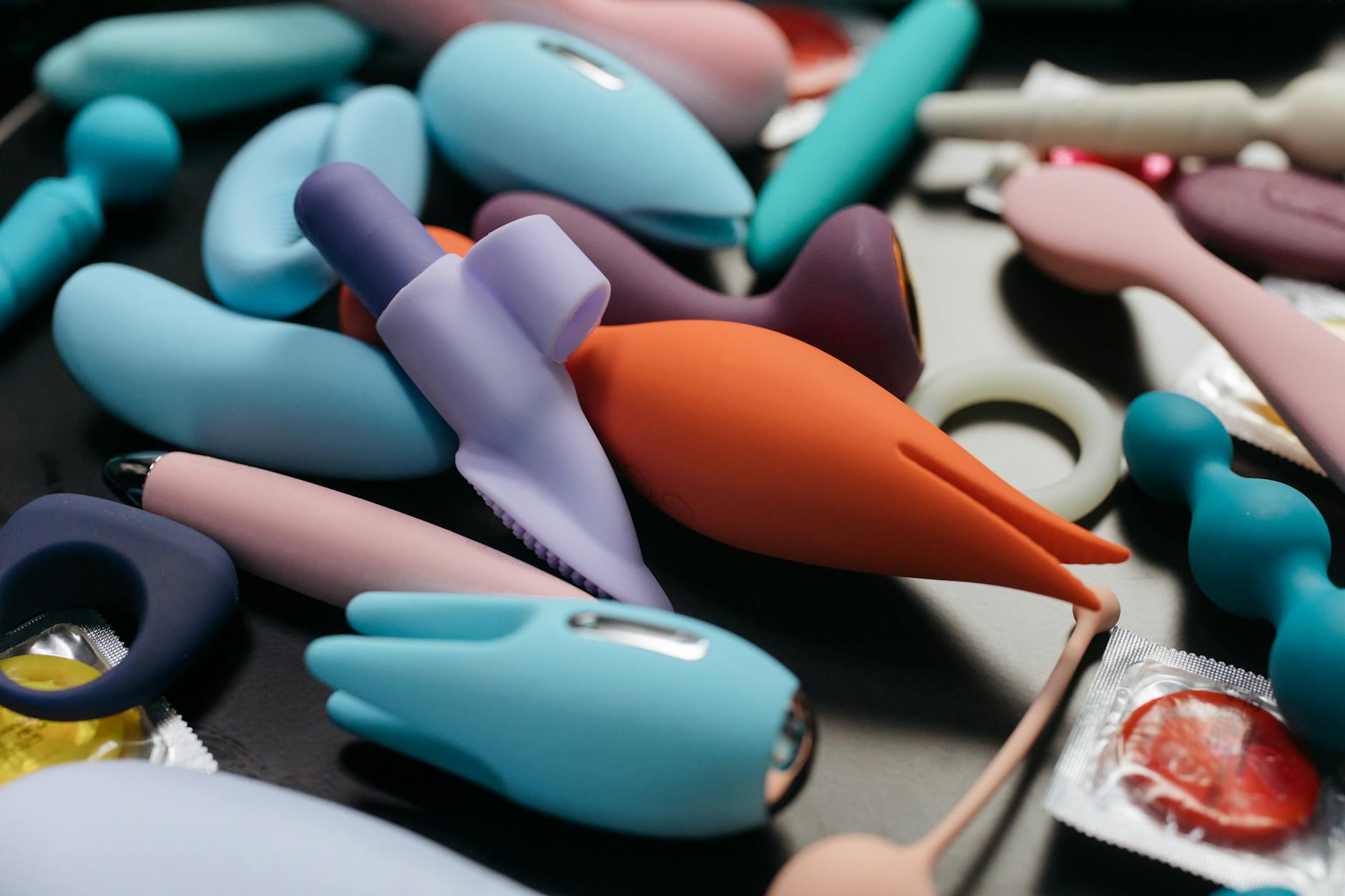An array of vibrant clitoral vibrators and intimate toys displayed in close-up, symbolizing pleasure exploration and reconnection.