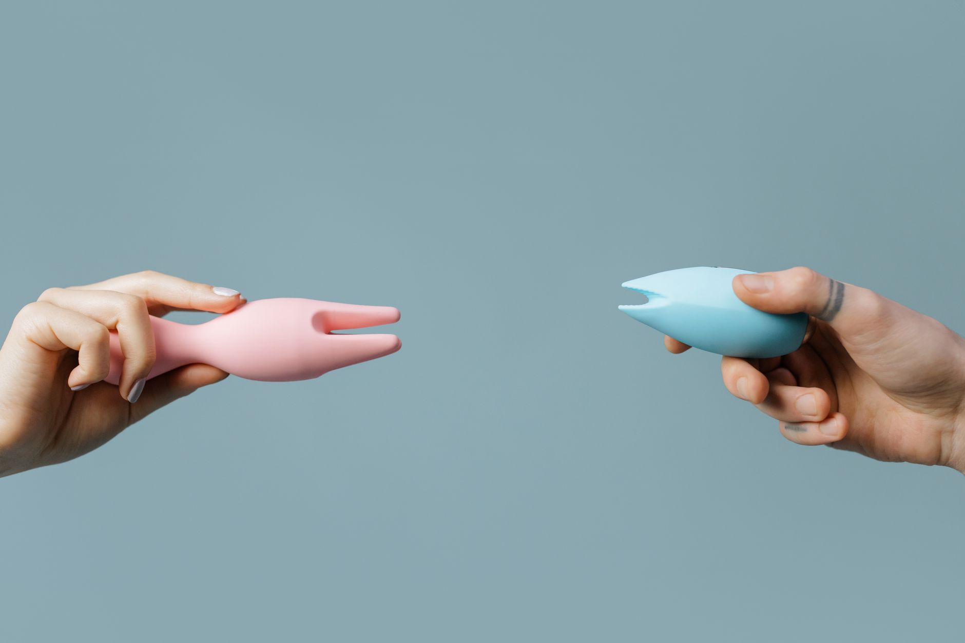 Woman holding colorful vibrators, representing sexual wellness tools for hormonal challenges