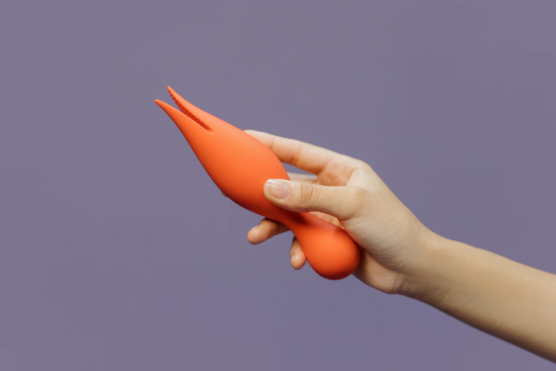 A hand holding a vibrator against a minimalistic backdrop, representing modern intimacy and pleasure reconnection.