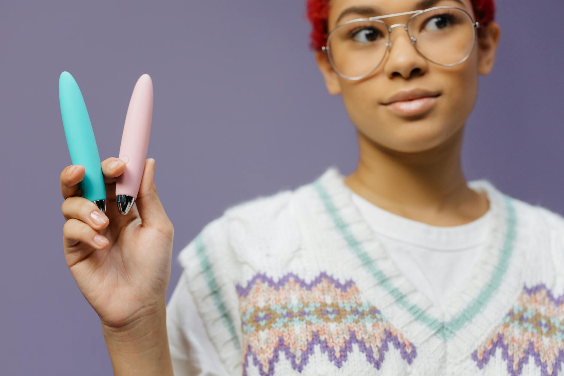 Woman holding colorful vibrators, representing choices for sexual wellness during recovery.